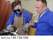 Apprentice using blowtorch, being supervised. Стоковое фото, агентство Ingram Publishing / Фотобанк Лори