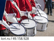 Drummers in red uniforms on a row at a spring parade with white gloves drumming on drums. Стоковое фото, агентство Ingram Publishing / Фотобанк Лори