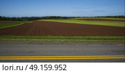 Road by ploughed field, Breadalbane, Prince Edward Island, Canada. Стоковое фото, агентство Ingram Publishing / Фотобанк Лори