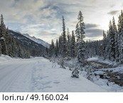 Snow covered road leading toward mountain range, Maligne Lake, Jasper, Jasper National Park, Alberta, Canada. Стоковое фото, агентство Ingram Publishing / Фотобанк Лори