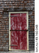 Closed red door on a Fishing shed at harbor, Peggy's Cove, Nova Scotia, Canada. Стоковое фото, агентство Ingram Publishing / Фотобанк Лори