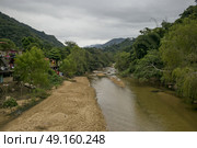 Scenic view of mountainside village by river, Yelapa, Jalisco, Mexico. Стоковое фото, агентство Ingram Publishing / Фотобанк Лори