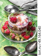 Raspberry ice-cream in mug. Raspberry ice cream with currants in glass cup.Sundae on rustic background. Стоковое фото, агентство Ingram Publishing / Фотобанк Лори