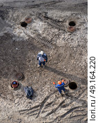 Top view of workers repairing underground heating mains through open hatches. Стоковое фото, фотограф Сергей Фролов / Фотобанк Лори