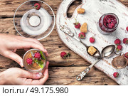Tea with raspberries. Tea cup with raspberry warming tea in hands. Стоковое фото, агентство Ingram Publishing / Фотобанк Лори