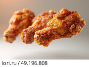 Crispy fried chicken wings presented against a soft background with a warm glow. Стоковое AI-изображение, AI-художник Климов Денис / Фотобанк Лори