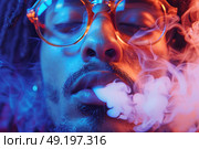 Young man exhales smoke in colorful lighting during nighttime gathering with friends. Стоковое AI-изображение, AI-художник Климов Денис / Фотобанк Лори