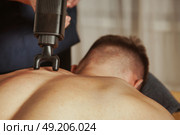 Effective Sports Massage Using Percussion Massager in a Relaxing Indoor Setting. Стоковое фото, фотограф Aleksandr Golubev / Фотобанк Лори