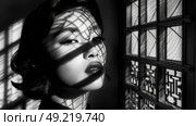 A womans face partially covered by the shadow cast by her head, creating a striking visual effect. Стоковое AI-изображение, AI-художник Данила Большаков / Фотобанк Лори
