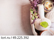 Massage setting with herbal compress balls ,fresh herbs and flowers and bathroom salts  on light background,top view. Healthy Lifestyle or Spa and wellness concept. Стоковое фото, агентство Ingram Publishing / Фотобанк Лори