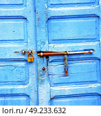 metal nail dirty     stripped paint in the brown   red wood door and rusty  knocker. Стоковое фото, агентство Ingram Publishing / Фотобанк Лори