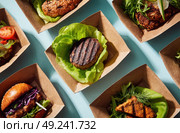 A variety of food items are displayed in paper trays, including hamburgers. Стоковое AI-изображение, AI-художник Ярославский Максим / Фотобанк Лори