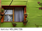 orange wood window and a green metal wall in la boca buenos aires argentina. Стоковое фото, агентство Ingram Publishing / Фотобанк Лори