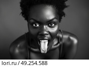A black and white portrait of a woman playfully sticking out her tongue at the camera. Стоковое AI-изображение, AI-художник Данила Большаков / Фотобанк Лори