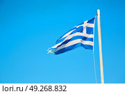 waving greece flag  in the blue sky and      flagpole. Стоковое фото, агентство Ingram Publishing / Фотобанк Лори