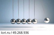 Newton's cradle in motion demonstrating physics principle of conservation of momentum and energy, often symbolizing decision making or cause and effect. Стоковое AI-изображение, AI-художник Ольга Сухарева / Фотобанк Лори