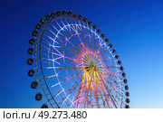 High neon ferris wheel at night in an amusement park Navruz or Anhor in Tashkent, Uzbekistan. (2023 год). Стоковое фото, фотограф Емельянов Евгений Викторович / Фотобанк Лори