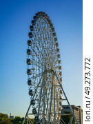 Tashkent, Uzbekistan - August 12, 2023: High ferris wheel at sunset or sunrise with blue sky in an amusement park Navruz or Anhor. Редакционное фото, фотограф Емельянов Евгений Викторович / Фотобанк Лори