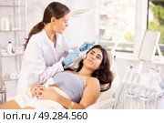 Aesthetician administering hardware facial procedure with ice hammer on young woman. Стоковое фото, фотограф Яков Филимонов / Фотобанк Лори