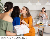 Two women have arrived for birthday celebration and presenting gift to birthday woman. Стоковое фото, фотограф Яков Филимонов / Фотобанк Лори
