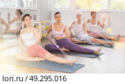 Girl using figure eight resistance band for exercise in pilates class. Стоковое фото, фотограф Яков Филимонов / Фотобанк Лори