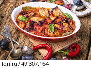 meat in plum sauce. meat stew in a sauce of autumn plums on a retro background. Стоковое фото, агентство Ingram Publishing / Фотобанк Лори