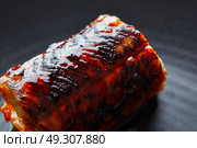Grilled smoked eel on black plate macro closeup detail. Стоковое фото, агентство Ingram Publishing / Фотобанк Лори