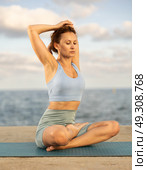 Yoga practice on embankment, female athlete fulfil carry out padmasana svastikasana, Siddhasana. Стоковое фото, фотограф Яков Филимонов / Фотобанк Лори