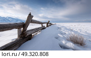 Rustic wooden fence buried in permafrost snow drift Life in permafrost conditions, climate change problems on the planet. Global warming. Стоковое AI-изображение, AI-художник ALLA YURTAYEVA / Фотобанк Лори