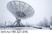 Ice encrusted satellite dish receiving signals in a blizzard. Life in permafrost conditions, climate change problems on the planet. Global warming. Стоковое AI-изображение, AI-художник ALLA YURTAYEVA / Фотобанк Лори