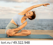 Yoga practice on embankment, female athlete fulfil carry out padmasana svastikasana, Siddhasana. Стоковое фото, фотограф Яков Филимонов / Фотобанк Лори