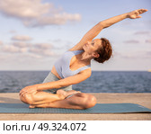 Yoga practice on embankment, female athlete fulfil carry out padmasana svastikasana, Siddhasana. Стоковое фото, фотограф Яков Филимонов / Фотобанк Лори