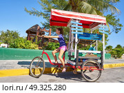Young girl with caribbean bicycle shop on tricycle of Mexico. Стоковое фото, агентство Ingram Publishing / Фотобанк Лори