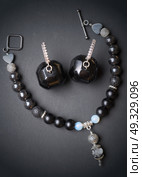 jewel handmade bracelet with semipreciouse stones and earrings with black  semiprecious gem jet at black background. Стоковое фото, агентство Ingram Publishing / Фотобанк Лори