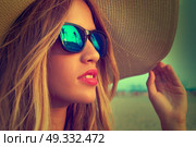 Blond teen girl sunglasses and pamela sun hat at palm tree sunset filtered image. Стоковое фото, агентство Ingram Publishing / Фотобанк Лори