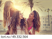 Best friends teen girls having fun on a beach sand at sunset. Стоковое фото, агентство Ingram Publishing / Фотобанк Лори