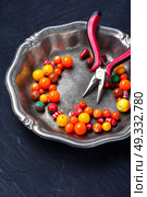 Bright plastic beads. Orange plastic beads for needlework in a stylish tray. Стоковое фото, агентство Ingram Publishing / Фотобанк Лори