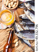 salted fish and beer. glass of beer, salted fish and nuts on a wooden table. Стоковое фото, агентство Ingram Publishing / Фотобанк Лори