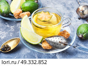 Tea with lime and feijoa. Hot tea with feijoa and lime on blue background. Стоковое фото, агентство Ingram Publishing / Фотобанк Лори