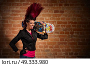 Young punk girl on brick wall background. Стоковое фото, агентство Ingram Publishing / Фотобанк Лори