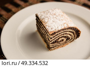 strudel with poppy seeds on a ceramic white plate on wooden background. Стоковое фото, агентство Ingram Publishing / Фотобанк Лори
