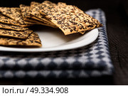 cookies with sunflower seeds and sesame seeds on a white plate with checkered napkin. Стоковое фото, агентство Ingram Publishing / Фотобанк Лори