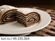 strudel with poppy seeds on a ceramic white plate on wooden background. Стоковое фото, агентство Ingram Publishing / Фотобанк Лори