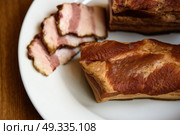 smoked pork ribs on white plate on wooden background. Стоковое фото, агентство Ingram Publishing / Фотобанк Лори
