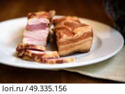 smoked pork ribs on white plate on wooden background. Стоковое фото, агентство Ingram Publishing / Фотобанк Лори
