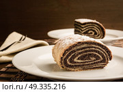 strudel with poppy seeds on a ceramic white plate on wooden background. Стоковое фото, агентство Ingram Publishing / Фотобанк Лори