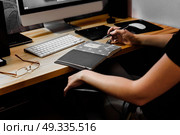designer girl at work at the table draws on the tablet, close the keypad, printer, computer. Стоковое фото, агентство Ingram Publishing / Фотобанк Лори