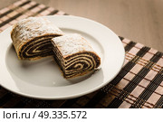 strudel with poppy seeds on a ceramic white plate on wooden background. Стоковое фото, агентство Ingram Publishing / Фотобанк Лори