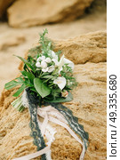 bouquet of a bride from feces and roses lies on a sandstone stone on the seashore. Стоковое фото, агентство Ingram Publishing / Фотобанк Лори