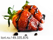 strawberries with a tail drenched in liquid chocolate on white background. Стоковое фото, агентство Ingram Publishing / Фотобанк Лори